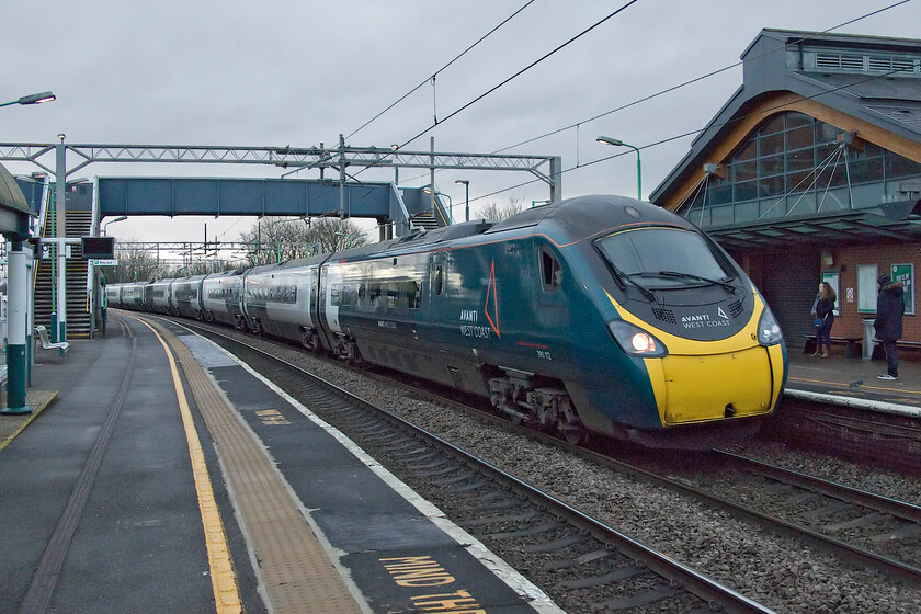 390112, VT 06.35 Manchester Picadilly-London Euston (1A06, 15L), Wolverton station 
 I am not at all sure as to why all trains were being diverted from the up fast to the up slow line at Hanslope Junction a short distance north of this spot at Wolverton station. However, with all up trains giving an obligatory blow on the horn in the distance I suspect that there were some orange jackets in the vicinity. 390112 works the 1A06 06.35 Manchester to Euston service through the station at a reduced speed as it was now competing with other much slower traffic. The up fast trains returned to the fast line in and around Milton Keynes. 
 Keywords: 390112 06.35 Manchester Picadilly-London Euston 1A06 Wolverton station