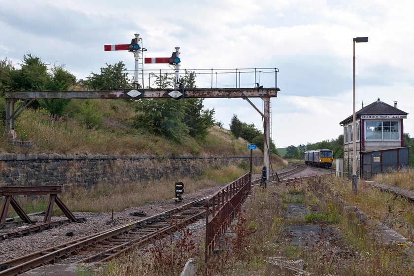 144022, NT 12.20 Leeds-Lancaster (2H13, 2L), Hellifield station 
 One of the very few signal gantries remaining on the network is at Hellifield. It is shawn of most of its arms now but is still in use. Between the gantry and the 1911 Midland 4C signal box 144022 approaches the station forming the 12.20 Leeds to Lancaster in a very similar position to one I photographed four years ago, see...... https://www.ontheupfast.com/p/21936chg/30016458751/x8-150118-nt-11-14-leeds-heysham Notice that in this direction, looking south east, that the cloud has begun to build and cover the sun, a portent of things to come later in the day! 
 Keywords: 144022 2H13 Hellifield station