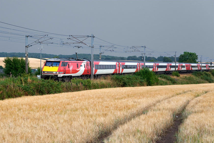 91117, GR 16.39 Peterborough-York (5X25, 81L), Grove Road Crossing SK717791 
 Against a dramatic black sky that was packed with electrical energy, 91117 'West Riding Limited' races north leading the 16.39 Peterborough to York with a reporting number of 5X25. This odd start point and number was due to the ensuing chaos caused by a huge storm affecting York and Leeds earlier in the day meaning trains were all out of place even some hours later. The train is seen approaching Grove Crossing just south of Retford. 
 Keywords: 91117 5X25 Grove Road Crossing SK717791