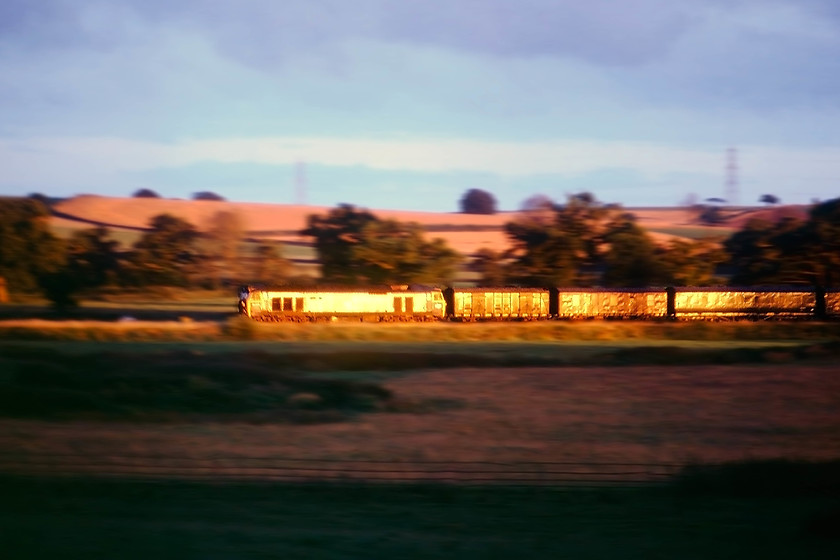 Class 50, up parcel working, Heazille Barton Farm campsite, Rewe SX954004 
 A glint shot that has a certain atmospheric air about it. In the dying evening sun, an unidentified class 50 heads past my campsite at Rewe between Stoke Canon and Hele and Bradninch. It is heading up and unidentified parcels working. In the consist appears to be a Southern Van, a GUV and an LMS van and thats just the first 3! Any help with the working or identification on the 50 would be appreciated. If it helps it was taken at about 20.30. The tape recording that I still have is equally as atmospheric complete with a menagerie of farm animals, all doing their best to compete with the throbbing class 50! 
 Keywords: Class 50 up parcel working Heazille Barton Farm campsite Rewe SX954004