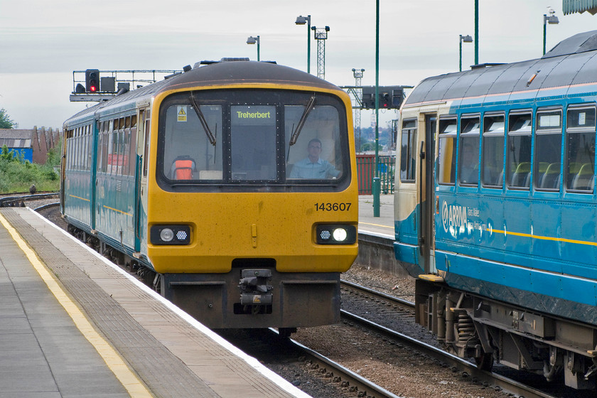 143607, AW 13.21 Cardiff Central-Cardiff Central ecs (5T28) & 142010, AW 13.27 Ebbw Vale Town-Cardiff Central (2F30), Cardiff Central station 
 These 'stopgap' Pacers have been a huge part of the railways in South Wales since the withdrawal of the first generation DMUs in the mid-1990s. Ironically, they have now been in service longer than the units that they replaced so these temporary trains have become something more than that! 143607 arrives into Central station with the 13.21 return ecs move whilst 142010 waits to work it next train after terminating with the 13.27 from Ebbw Vale. 
 Keywords: 143607 13.21 Cardiff Central-Cardiff Central ecs 5T28 142010 13.27 Ebbw Vale Town-Cardiff Central 2F30 Cardiff Central station Arriva Trains Wales Pacer