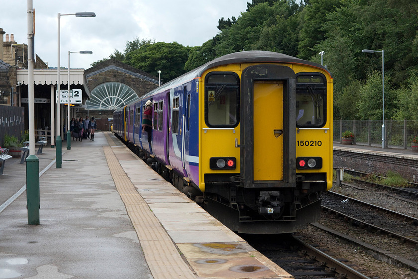 150210, NT 13.29 Buxton-Manchester Piccadilly (2H01), Buxton station 
 150210 sits at Buxton station. It will work the 2H01 13.29 to Manchester Piccadilly. Notice the famous and recently restored glass and wrought iron fan window in the wall at the end of the station. 
 Keywords: 150210 13.29 Buxton-Manchester Piccadilly 2H01 Buxton station