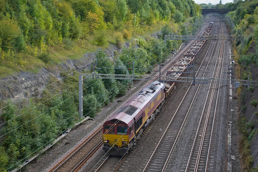 66063 & 66085, 12.00 Fenny Stratford-Bescot up engineering sidings (6R06), Roade cutting 
 With subtle autumn changes to the colour of the foliage that now has enveloped the sides of the cutting at Roade much in evidence 66063 leads a heavily loaded set of MKA and JNA wagons. The wagons a full of old concrete sleepers that are going for recycling at Bescot. The train, running as 6R06, originated at Fenny Stratford and has 66085 on the rear. 
 Keywords: 66063 66085 12.00 Fenny Stratford-Bescot up engineering sidings 6R06 Roade cutting EWS