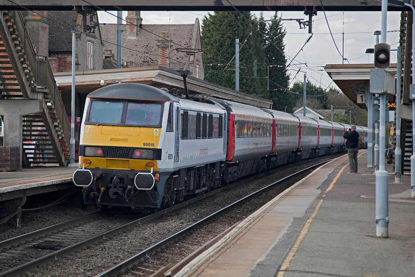 90015, GA 14.00 London Liverpool Street-Norwich (1P34, 1L), Stowmarket station 
 90015 'Colchester Castle' pushes the 14.00 Liverpool Street to Norwich 1P34 service away from Stowmarket station. The replacement concrete footbridge can be seen in this picture. This was installed when the line was electrified to give greater clearance for the wires. The old footbridge was carefully removed and lives on at the superb Weybourne station on the North Norfolk Railway. 
 Keywords: 90015 1P34 Stowmarket station