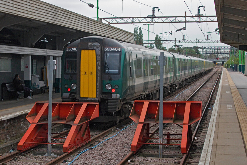 350404, LN 06.42 Northampton-Birmingham New Street (2Y07, 1E), Northampton station 
 The first train of our day out to the Bristol area sits in one of Northampton's two north-facing bay platforms. Andy and I travelled aboard 350404 that was to work the 06.42 to Birmingham New Street. It is always good to be able to travel on a 350/4 former TransPennine Express set as the interior is roomier due to a different seating configuration than in the other two subsets. However, intensive use by London Northwestern has begun to show with the formally smarter interiors of these ten units now beginning to deteriorate and take on that distinctive interior odour that the class 350's seem to have; has anybody else noticed that or is it just me? 
 Keywords: 350404 06.42 Northampton-Birmingham New Street 2Y07 Northampton station London Northwestern Desiro