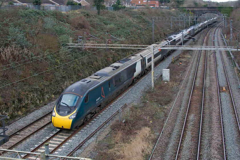 390128, VT 10.39 Wolverhampton-London Euston (1B37, 7L), A508 bridge 
 390128 passes Roade at the southern end of the famous cutting working the 10.39 Wolverhampton to Euston AWC service. I am standing on the former A508 road bridge. I say former as the recently opened Roade bypass has taken the road's number so the old road through the village will be reclassified I suspect. All that I do know is that this location is extremely quiet now with no constant lines of vehicles passing directly behind where I am standing! 
 Keywords: 390128 10.39 Wolverhampton-London Euston 1B37 A508 bridge