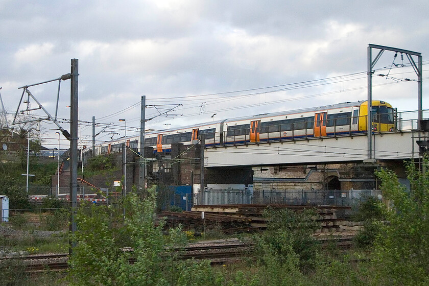 Class 378, LO 18.53 Richmond-Stratford, Willesden Junction High Level station 
 An unidentified London Overground Class 378 is seen arriving at Willesden Junction High Level station working the 18.53 Richmond to Stratford service. This unusual angle is taken from a passing Southern service as it slows to almost a walking pace in preparation to swing south and under the WCML tracks before heading off on to towards southern territory via Mitre Brisge Junction. 
 Keywords: Class 378 18.53 Richmond-Stratford Willesden Junction High Level station London Overground