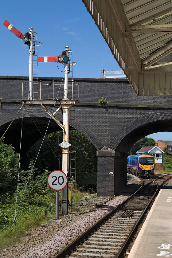 185151, TP 10.29 Manchester Airport-Blackpool North, Poulton-le-Fylde station 
 With the down home bracket signal making a fine sight against the azure blue sky at Poulton-le-Fylde station 185151 has just departed with the 10.29 Manchester Airport to Blackpool service. The L&Y 1896 signal box can be seen in the distance. The right-hand submissive doll holds the down home signal for the Fleetwodd branch that peels off to the right after the bridge. This branch has not seen any traffic for many years despite regular calls for the mothballed route to be re-opened. 
 Keywords: 185151 10.29 Manchester Airport-Blackpool North Poulton-le-Fylde station TE Trans Pennine Express