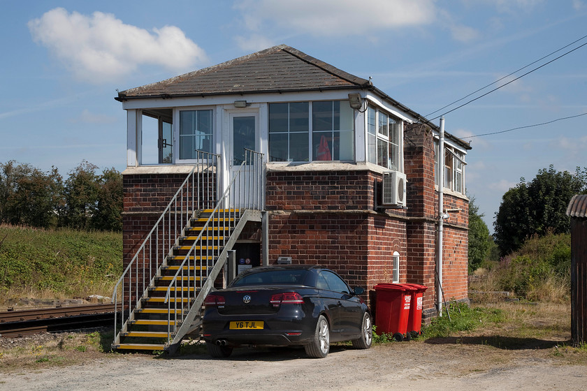 Woofferton Junction signal box (LNW & GW Joint, c.1875) 
 When I visited Woofferton Junction signal box in 1981 I was permitted to venture on to the tracks to take picture of the front of the box, see..... https://www.ontheupfast.com/p/21936chg/30033442595/x3-woofferton-junction-signal-box Not on today's world, where I have had to make do with a shot of the back taken over a gate. This is another example of the LNW and GW Joint Type 1 box built in 1875. It was extended in 1914 when a new GWR frame was installed. In recent years, it has undergone a number of changes that have spoilt its looks somewhat, such as new windows, aluminium steps and an air conditioner. 
 Keywords: Woofferton Junction signal box