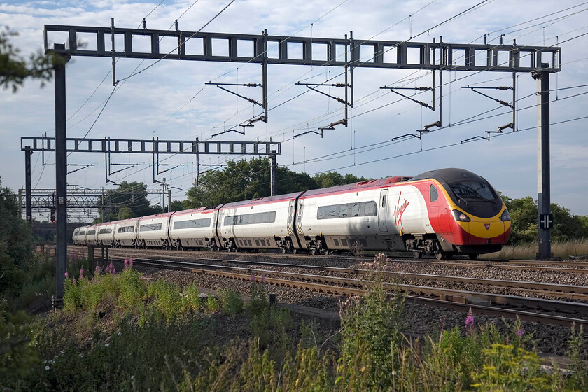 390050, VT 06.43 London Euston-Birmingham New Street, between Roade & Ashton 
 Catching some morning sun on its flanks as it passes between Roade and Ashton, 39005 'Virgin Invader' works the 06.43 Euston to Birmingham New Street service. 
 Keywords: 390050 06.43 London Euston-Birmingham New Street between Roade & Ashton Virgin Pendolino Virgin Invader