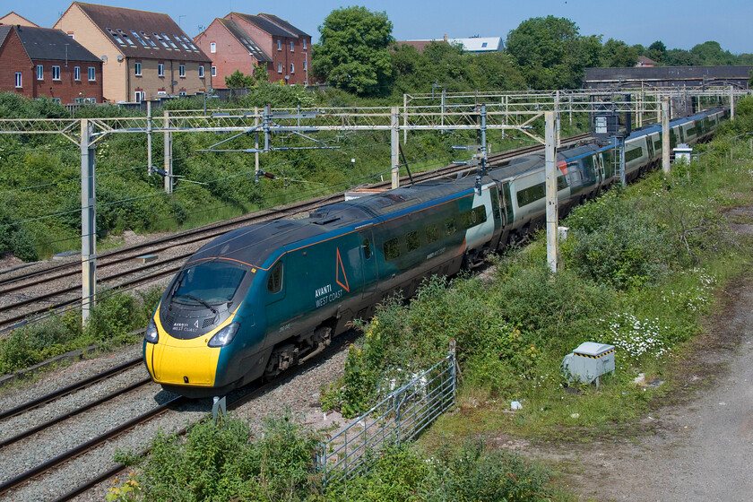 390045, VT 09.21 Manchester Piccadilly-London Euston (1A14, 10E), site of Roade station 
 Being a Sunday morning engineering works have closed the fast lines from Hanslope Junction to Hilmorton Junction near Rugby meaning all trains are diverted via the 'slow' line through Northampton. Emerging from Roade cutting, 390045 'Birmingham Pride' forms the 09.21 Manchester Piccadilly to Euston AWC service on a glorious early summer's day. 
 Keywords: Birmingham Pride 390045 09.21 Manchester Piccadilly-London Euston 1A14 site of Roade station