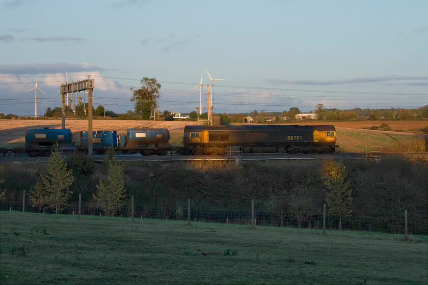 66701, 11.52 King's Norton OT Plant-Bletchley (3J01, 5L), Roade Hill 
 With the last vestiges of sunshine illuminating parts of the train 66701 leads the daily 11.52 King's Norton to Bletchley RHTT just south of Roade. The 3JO1 takes a circuitous trip around and through Birmingham to Rugby, then north as far as Stafford and south to Bletchley and along the Marston Vale line to Bedford and back. Unfortunately, my chosen location, to maximise lighting, did not quite come off as intended. With the train running a little late the sun has just gone too low and the full length of the RHTT service did not quite fit in the space available; never mind though! 
 Keywords: 66701 11.52 King's Norton OT Plant-Bletchley 3J01 Roade Hill GBRf