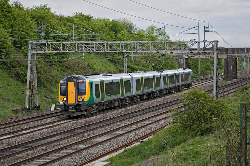 350113, LM 16.49 London Euston-Birmingham New Street, Roade 
 350113 approaches Roade working the 16.49 Euston to Birmingham New Street London Midland service. Like nearly all of their services since the start of the winter timetable in December this is a single-set four-car train. This decision has not been a resounding success with many services over-crowded, thus, I wonder when the summer timetable commences in a couple of weeks if services revert to double sets again? 
 Keywords: 350113 16.49 London Euston-Birmingham New Street Roade