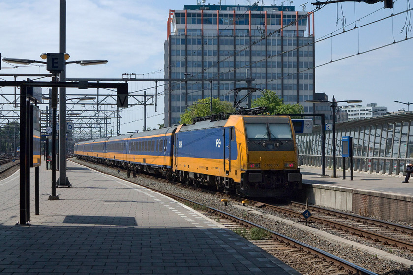 186 038, 15.37 Amsterdam Central-Breda (IC 948), Amsterdam Central station 
 186 038 brings up the rear of the 15.37 to Breda as it leaves Amsterdam Central station. This is a very smart rake of stock with a pair of matching locomotives, we could learn a lot from how the Dutch state railways operate their services even though they have their finger in many of our UK private operations that are not run quite so successfully! 
 Keywords: 186 038 15.37 Amsterdam Central-Breda IC 948 Amsterdam Central station