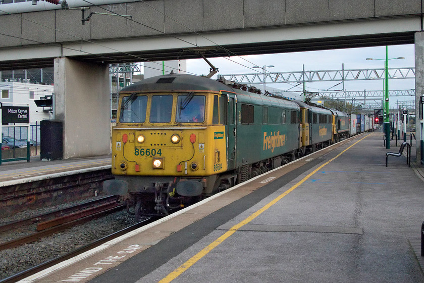 86604, 86607 & 66538, 11.34 Felixstowe North-Trafford Park (4M87), Milton Keynes Central station 
 I had been watching the progress of the 4M87 on my mobile 'phone expecting to see a class 66 leading the train. However, as it came into view in the distance I realised that it was something different. I am not sure if this was a positioning move or as a result of failure but 66453 is tucked inside behind vintage 86604 and 86607 as it passes at considerable speed through Milton Keynes Central station. The 11.34 Felixstowe to Trafford Park Freightliner did leave Ipswich very late but had gained a lot of its lost minutes by the time it was here at Milton Keynes so I suspect that it could have been a problem with 66538. 
 Keywords: 86604 86607 66538 11.34 Felixstowe North-Trafford Park 4M87 Milton Keynes Central station