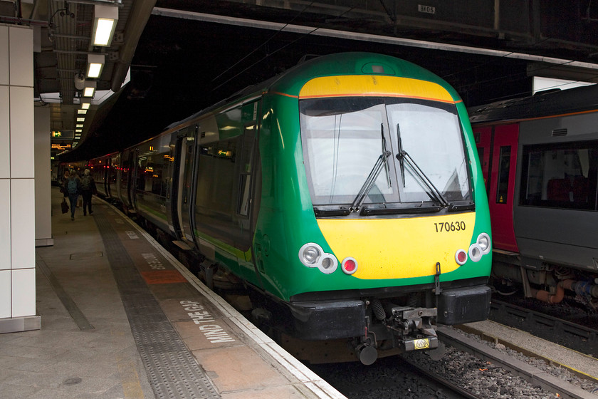 170630, LM 12.49 Birmingham New Street-Hereford (1V27, 2L), Birmingham New Street station 
 Just poking its nose out of the gloom at New Street is 170630. I was about to board this train working the 12.49 to Hereford as far as far as Droitwich. These class 170s have been good since their introduction in 1998 but I still have reservations about their ride and comfort, a bottle of water or a cup of coffee tend to froth and migrate their way across the table when the train is running at speed! 
 Keywords: 170630 1V27 Birmingham New Street station