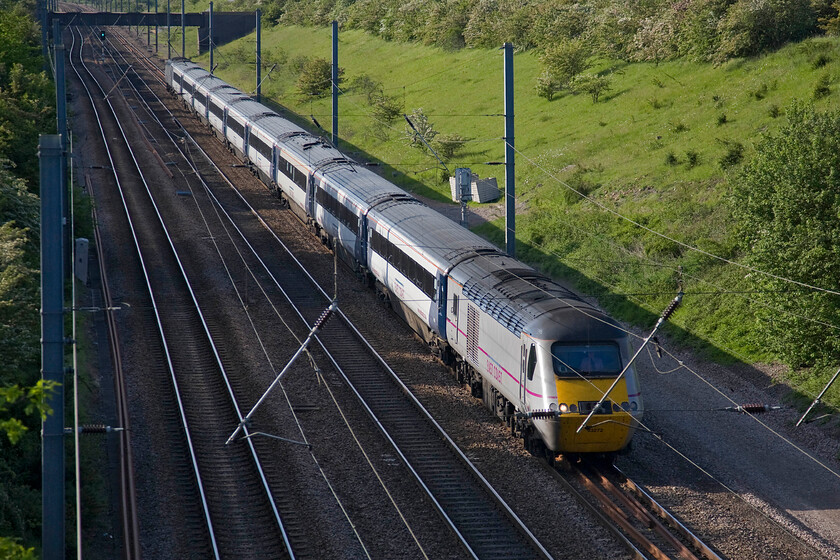 43272, 14.00 Edinburgh Waverley-London King's Cross (1E18), New England bridge TL219796 
 HST power car 43272 leads the 14.00 Edinburgh to King's Cross 1E18 East Coast service just south of Connington. The photograph is taken from the lofty height of New England bridge that carries a minor road over the line and the cutting it is in that heads towards the village of Wennington. The bridge in the distance might well have afforded a better vantage point but that would be tricky as it is actually an aqueduct carrying a small watercourse over the line. 
 Keywords: 43272 14.00 Edinburgh Waverley-London King's Cross 1E18 New England bridge Wood Wennington TL219796