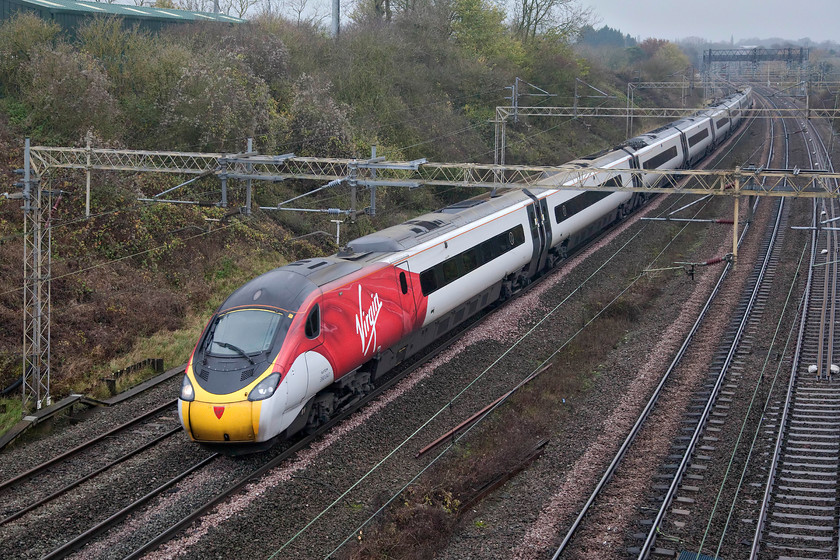 390047, VT 09.47 Liverpool Lime Street-London Euston (1A22, RT), Victoria bridge 
 390047 sweeps around the right-hand curve just south of Roade and will build its speed up on the quadruple and largely straight track on the final sixty miles of its journey to London. It is working the 1A22 09.47 Liverpool Lime Street to Euston and the livery certainly brightens up a dismal November day that represents everything that I dislike about this time of year! 
 Keywords: 390047 09.47 Liverpool Lime Street-London Euston 1A22 Victoria bridge Virgin Pendolino Virgin Trains