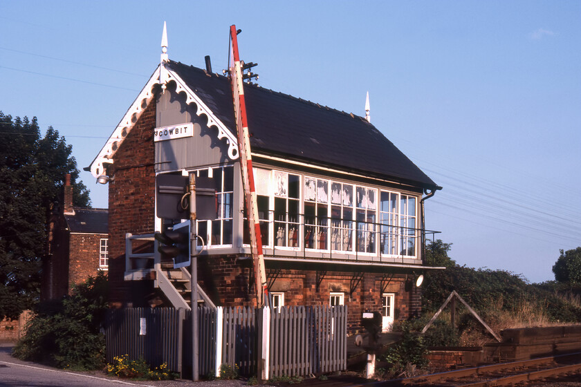 Cowbit signal box (GN, 1882) 
 In lovely late afternoon sunshine Cowbits (pronounced Cubbit) signal box is seen adjacent to the former station (closed 11.09.61) and the level crossing where Stone Gate Road crossed the doomed GN & GE Joint line. The signal box had just eighteen months left in operation before BR completed its plans to shut the line between Spalding and March, like so many closures this is one that is seen now as a mistake with it offering an alternative route for freight taking it away from the ECML. The delightfully ornate 1881 Great Northern box still stands having been the subject of a long and protracted conversion into a private residence, see..... https://www.ontheupfast.com/p/21936chg/30044473953/former-cowbit-signal-box-gn 
 Keywords: Cowbit signal box Great Northern