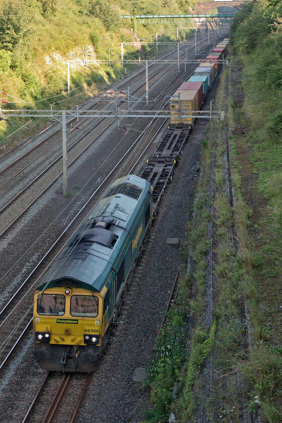 66568, 03.39 Garston-London Gateway (4L52, 10E), Roade cutting 
 With two freights (4L52 and 4M86) approaching fast I had it in my head that they would cross completely passing me here in Roade cutting. Luckily, they were seconds apart meaning that I could grab two photographs. Firstly, 66568 heads south leading the 03.39 Garston to London Gateway making very sedentary progress. 
 Keywords: 66568 03.39 Garston-London Gateway 4L52 Roade cutting Freightliner