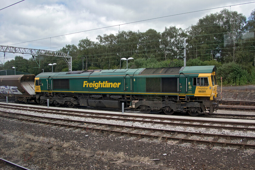 66591, unidentified working, Crewe south 
 Despite all the technology available and even a fellow enthusiast having access to Freightmaster, I could not identify this working being led by 66591! The Freightliner Class 66 is leading a motley rake of HHA wagons seen at Crewe south. I believe it was leading the set of wagons either to or from repair/storage at the former MoD Central Ordnance Depot at Warrington that is also the site of the failed rail freight terminal. 
 Keywords: 66591 unidentified working Crewe south