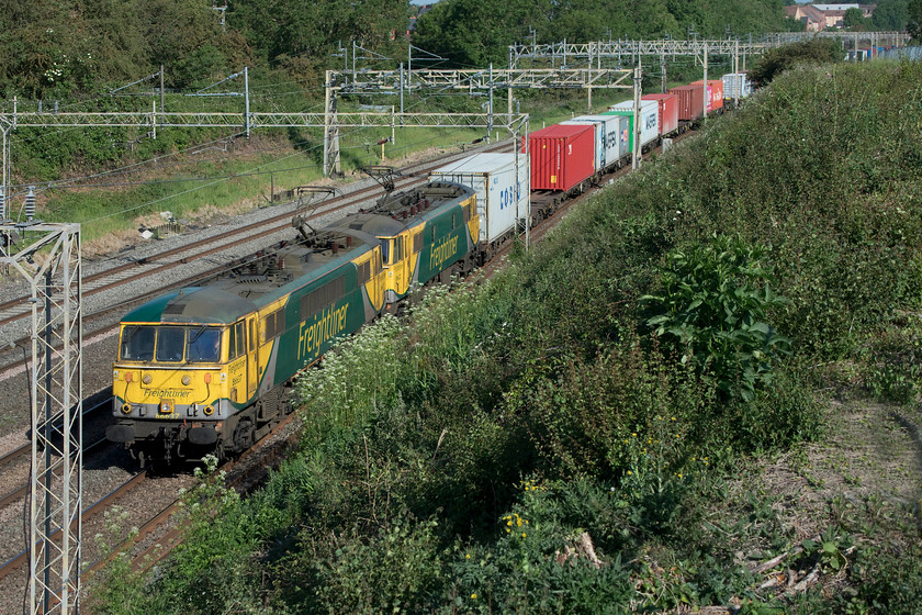 86637 & 86622, 04.57 Trafford Park-Felixstowe North (4L97, 42E), Ashton Road bridge 
 It is remarkable how quickly the embankments of the railway grow back after clearance. Back in February just after the trees and greenery had been removed I took a photograph at this spot, see.... https://www.ontheupfast.com/p/21936chg/28900947604/x323227-12-37-allerton-depot-wolverton However, some three months later the view is disappearing fast! In their revised livery 86637 and 86622 lead the 04.57 Trafford Park to Felixstowe 4L97 Freightliner as they approach Ashton Road bridge just south of the village of Roade. 
 Keywords: 86637 86622 04.57 Trafford Park-Felixstowe North 4L97 Ashton Road bridge AL6 Cans Freightliner