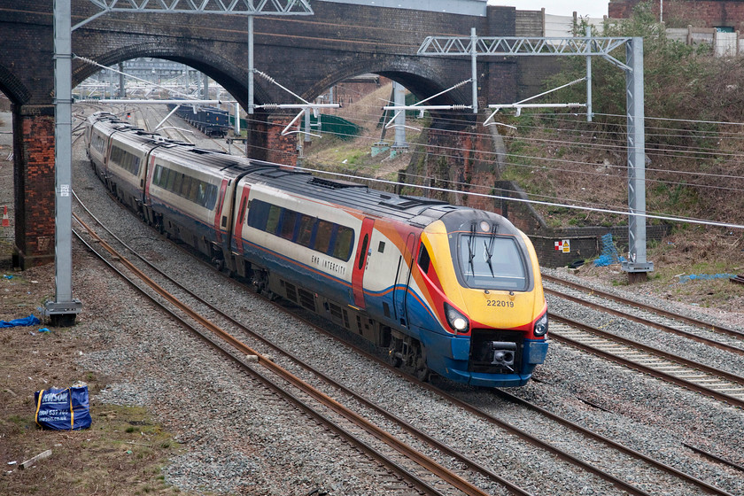 222019, EM 07.31 Derby-London St. Pancras (1C17, 1L), Wellingborough Driver Way bridge 
 222019 approaches Wellingborough station passing under Mill Road bridge working the 07.31 Derby to St. Pancras service. This totally new view is from the bottom of a bank to the northern side of the huge new Driver Way bridge that opened at the end of 2019. Whilst the view is a little limited at least it is sufficiently low to enable the trains to be seen below the height of the wiring. 
 Keywords: 222019 07.31 Derby-London St. Pancras 1C17 Driver Way bridge EMR East Midlands Railway Meridian Wellingborough