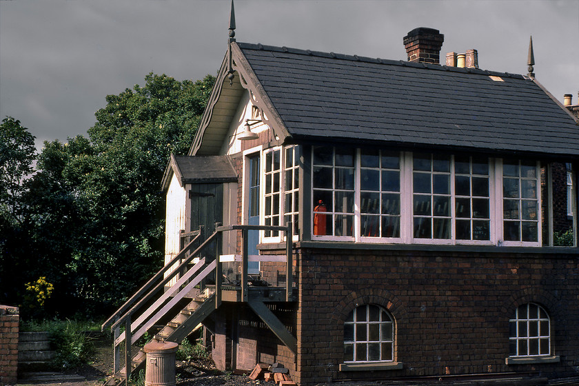 Radway Green Signal Box (NSR, C.1881) 
 On our long drive home in the Mini we dived off the M6 in Staffordshire and took lunch in the car park of an MOD establishment at Radway Green. This was adjacent to the Crewe to Kidsgrove line and the station that closed back in 1966 but mechanical signalling still controlled the line. As Radway Green signal box was located on the up line that ran east to west on a sunny afternoon such as this the front is in shadow! The box was a North Staffordshire Railway Company type 1 structure dating from 1881. It survived until 19.07.85 being decommissioned as part of the Crewe re-modelling with the railway town a short distance to the west. The line has since been electrified and passenger services have returned with it enjoying direct trains to London operated by London Northwestern. 
 Keywords: Radway Green Signal Box