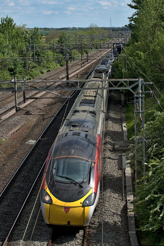 390107, VT 14.57 London Euston-Manchester Piccadilly (1H16, RT), Victoria bridge 
 In lovely late-spring sunshine, 390107 passes Victoria bridge between Roade and Ashton on the southern WCML forming the 14.57 Euston to Manchester Piccadilly. This was the first of the Pendolinos to receive Virgin's revised 'flowing silk' livery but it will not carry it for much longer as Virgin have not been awarded the WCML franchise again from November with a new operator (as yet, unnamed) taking over putting their new stamp and identity on the Pendolinos and Voyagers. 
 Keywords: 390107 14.57 London Euston-Manchester Piccadilly 1H16 Victoria bridge