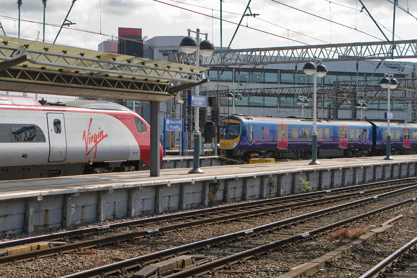 390135, VT 10.15 Manchester Piccadilly-London Euston (1A22) & 185148 TP 09.55 Manchester Airport-Cleethorpes (1B72), Manchester Piccadilly station 
 390135 'City of Lancaster' waits to leave Manchester Piccadilly with the 1A22 10.15 to London Euston. Meanwhile, beyond the Pendolino 185148 leaves with the 09.48 to Cleethorpes. Unfortunately, I have not quite got the Transpennine train positioned quite right with the rear of it partially obscured by a signal; taking going away pictures is always more tricky! 
 Keywords: 390135 10.15 Manchester Piccadilly-London Euston 1A22 185148 09.55 Manchester Airport-Cleethorpes 1B72 Manchester Piccadilly station Virgin Pendolino Trans Pennine Express City of Lancaster