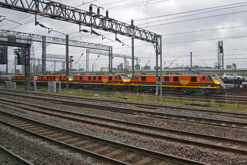 90007, 90003, 90012 & 90008, stabled, Wembley Yard 
 There is usually a fair collection of locomotives in Wembley Yard but it is unusual to see a line up of Class 90s. All in their matching DB Cargo liveries 90007, 90003, 90012 and 90008 await their next turn of duties. 
 Keywords: 90007 90003 90012 90008 stabled Wembley Yard Freightliner