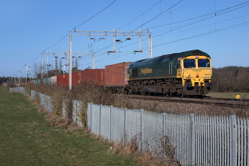 66502, 06.15 Trafford Park-Felixstowe North (4L97, 1L). Wilson's Crossing 
 66502 'Basford Hall Centenary 2001' leads the 4L97 06.15 Trafford Park (Manchester) to Felixstowe Freightliner service. The train is seen passing Wilson's Crossing just north of Northampton on a beautiful late winter's day with the first day of spring (meteorologically speaking) still two days away! 
 Keywords: 66502 06.15 Trafford Park-Felixstowe North 4L97 Wilson's Crossing Freightliner Basford Hall Centenary 2001