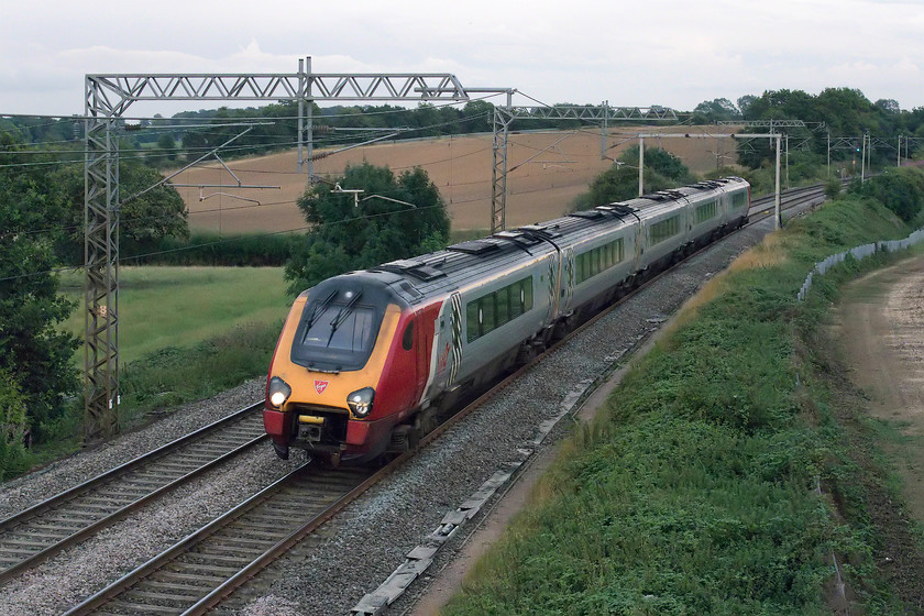 221113, VT 19.08 London Euston-Holyhead (1D93), Milton Crossing 
 There is no mistaking the approach of a class 221! The row from their Cummins QSK19 diesel engines, one per carriage, each producing 750hp is distinctive and far from subtle! 221113 is working the 19.08 Euston to Holyhead and is seen passing Milton Crossing just north of Roade cutting that is just around the curve in the background. 
 Keywords: 221113 19.08 London Euston-Holyhead 1D93 Milton Crossing