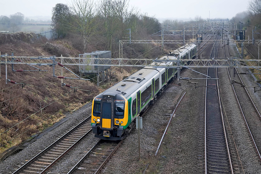 350372, LN 10.29 London Euston-Birmingham New Street (1W09, 5L), Victoria Bridge 
 With the fields in the background hardly visible through the gloom, 350372 heads the 10.29 Euston to Birmingham New Street past Victoria Bridge just south of Roade. 
 Keywords: 350372 10.29 London Euston-Birmingham New Street 1W09 Victoria Bridge