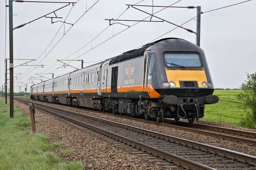 43468, GC 14.12 Sunderland-London King's Cross (1A65), Frinkley Lane crossing SK906436 
 Buffer fitted 43468 leads Grand Central's 14.12 Sunderland to King's Cross HST service past Frinkley Lane crossing just short distance south of Claypole. Much as I understand why buffer beams were fitted to some HST power cars in the late 1980s due to the late delivery of DVTs to the ECML they really do nothing for the aesthetics of the clean and uncluttered design of the power cars. 
 Keywords: 43468 14.12 Sunderland-London King's Cross 1A65 Frinkley Lane crossing SK906436 Grand Central HST