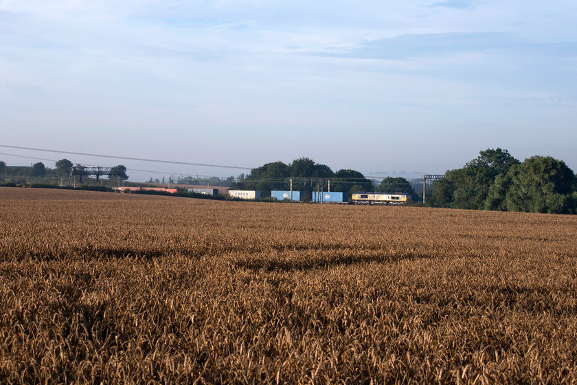 66703, 03.18 Felixstowe North-Trafford Park (4M21), between Roade & Ashton SP762511 
 With the wheat field in the foreground still awaiting harvesting, 66703 'Doncaster PSB 1981-2002' glints in the early morning sun leading the 03.18 Felixstowe to Trafford Park Freightliner. This 66 arrived in the UK during March 2001 and was named nearly two years later in December 2002. 
 Keywords: 66703 03.18 Felixstowe North-Trafford Park 4M21 between Roade & Ashton SP762511