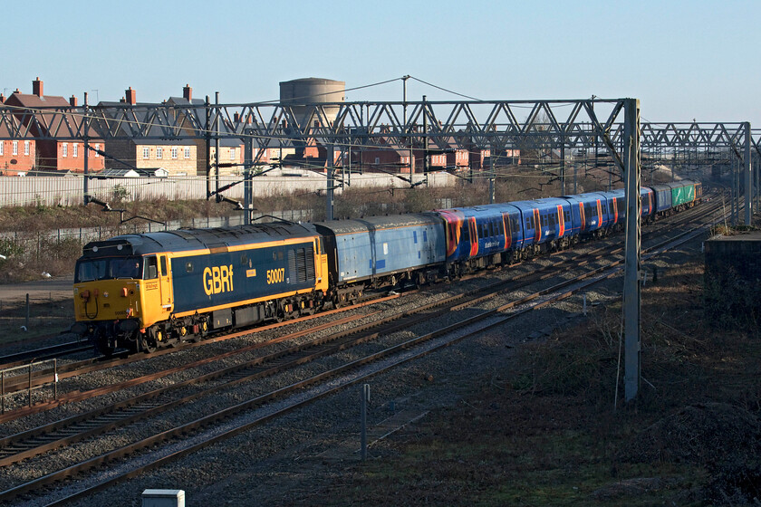 50007 458505 & 50049, 11.22 Clapham Yard-Widness Transport Tech (5Q26, 5E), site of Roade station 
 A glorious if a little incongruous scene on the southern portion of the WCML at Roade! Wearing its very smart GBRf livery 50007 'Hercules' leads a South West Railway unit with 50049 'Defiance' bringing up the rear. SWR's 458505 was being dragged as the 5Q26 11.22 Clapham Yard to Widness Tech for an overhaul and refit as are all members of this class over the coming months, a process that started last summer. 
 Keywords: 50007 458505 50049 11.22 Clapham Yard-Widness Transport Tech 5Q26 site of Roade station Defienace Hercules GBRf SWR South West Railway