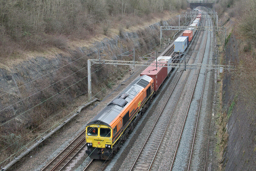 66415, 07.50 Felixstowe North-Lawley Street (4M94, 24E), Roade cutting 
 Brightening up the gloomy depths of Roade cutting 66415 'You Are Never Alone' heads north leading the 4M94 07.50 Felixstowe to Lawley Sreet Freightliner. Unlike what I have witnessed in the first few weeks of the year Freightliner and other services appear to be much better loaded now after a period of very lightly loaded services. 
 Keywords: 66415 07.50 Felixstowe North-Lawley Street 4M94 Roade cutting You Are Never Alone Freightliner