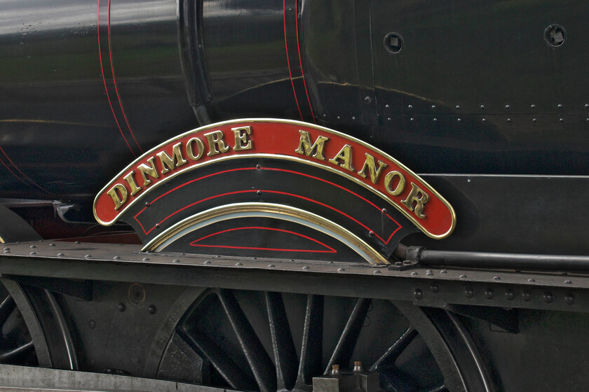 Nameplate, 7820, 12.35 Broadway-Cheltenham Racecourse, Toddington station 
 Dinmore Manor was the one hundred and fourth locomotive to be rescued from Dai Woodham's Barry scrapyard which she left in September 1979. However, after several moves between heritage centres rebuilding did not take place until 1985 with an eventual return to steam in 1995. The manor then worked for nine years on the West Somerset Railway giving pretty near faultless service before entering the workshop for a much-needed overhaul. The locomotive finally re-entered service in the G&WR in April 2014 where it has been ever since. The nameplate is seen attached to the flank of the locomotive above one of its 5 ft 8 in driving wheels whilst it pauses at Toddington station working the 12.35 Broadway to Cheltenham Racecourse service. 
 Keywords: 7820 12.35 Broadway-Cheltenham Racecourse Toddington station Dinmore Manor nameplate