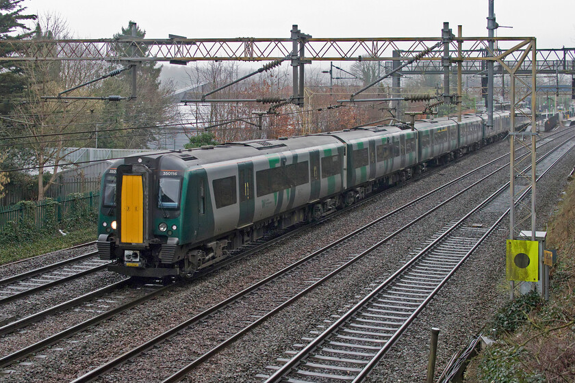 350116, LN 09.09 London Euston-Milton Keynes Central (2K15, 1L), Apsley 
 Having stopped at Apsley station, seen in the background, 350116 and another unidentified unit accelerate away working the 2K15 09.09 Euston to Milton Keynes 'stopper' service. Apsley station was opened much later than many others in September 1938. The station building is a small but functional affair designed by the LMS' favoured architect William Henry Hamlyn. Passenger numbers were hit very hard during the 2020/2021 pandemic year but they have recently begun to bounc back but are still running at half of the pre-COVID figure. 
 Keywords: 350116 09.09 London Euston-Milton Keynes Central 2K15 Apsley London Northwestern Desiro