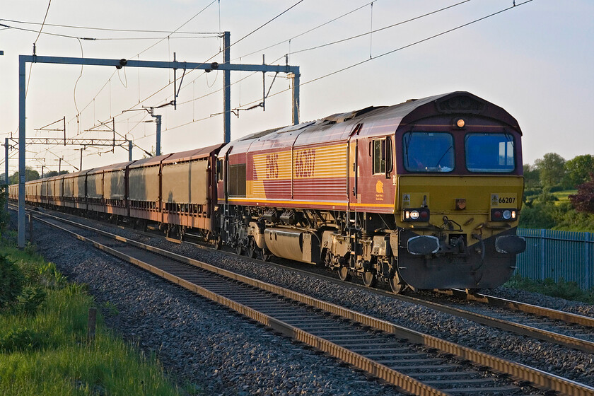 66207, 16.57 Halewood-Southampton Eastern Docks (6O38), Milton Malsor 
 The first of two up cartics within about fifteen minutes of each other passes Milton Malsor between Northampton and Roade. Catching some glints from the setting sun EWS liveried 66207 leads the 6O38 16.57 Halewood to Southampton Docks. The train appeared to be well-loaded with JLR vehicles going for export but it was difficult to see exactly what they were through the protective skirting. 
 Keywords: 66207 16.57 Halewood-Southampton Eastern Docks 6O38 Milton Malsor