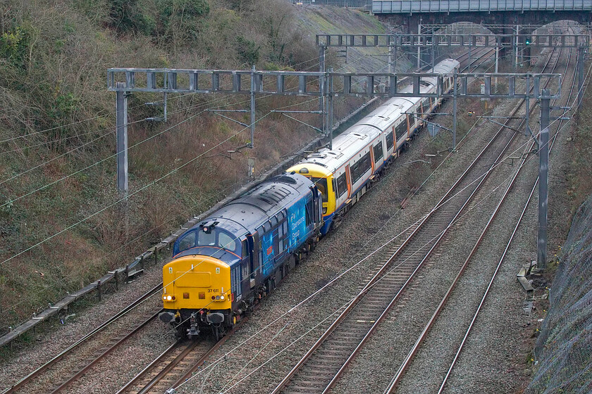 37611 & 378225, 10.46 New Cross Gate-Widness Transport Tech (5Q46, 5E), Hyde Road bridge 
 37611 'Denise' was certainly being driven by an enthusiastic driver as it progressed along the WCML in Northamptonshire. Indeed, I could hear the Class 37 some distance away leading the 5Q46 10.46 New Cross Gate to Widness Transport Tech. Capitalstar 378225 is being towed to the Merseyside facility for overhaul work on behalf of London Overground. 
 Keywords: 37611 378225, 10.46 New Cross Gate-Widness Transport Tech 5Q46 Hyde Road bridge Denise