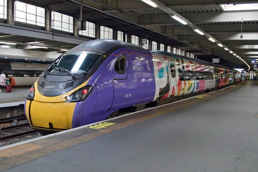 390119, VT 12.20 London Euston-Manchester Piccadilly (1H24, 2L), London Euston station 
 This Pendolino in its striking livery has illuded my camera's lens many times with just two images of it recorded since the repaint was undertaken during the COVID summer of 2020. On arrival at Euston 390119 'Progress' was on the adjacent platform to our incoming service waiting to work the 1H24 12.20 to Manchester. I like the unique Avanti West Coast Pride livery applied to this otherwise anonymous Pendolino. 
 Keywords: 390119 12.20 London Euston-Manchester Piccadilly 1H24 London Euston station Avanti West Coast Pendolino Progress