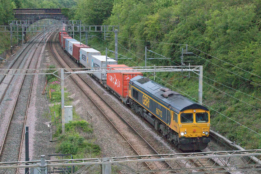 66713, 14.18 Trafford Park-Felixstowe North (4L18, 6E), A508 bridge 
 Within two minutes of arriving at this spot on the A508 bridge in Roade, I saw the reflection of 66713 'Forest City's' high-intensity light on the shiny railhead under Hyde Road bridge in the distance. It is leading the 4L18 14.18 Trafford Park to Felixstowe North. I had spotted 4M57 heading north and it was just approaching Bletchley at this time. Not a problem for me to get to the old station footbridge but I had to stop at the garage to get bread; would I make it? 
 Keywords: 66713 14.18 Trafford Park-Felixstowe North 4L18 A508 bridge GBRf Freightliner Forest City