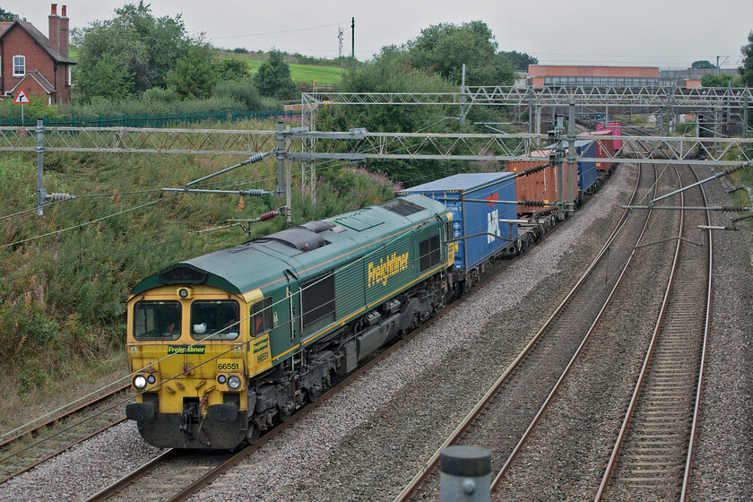 66551, 09.31 Crewe Basford Hall-Southampton MCT (4O35, 7L), Norton Bridge SJ869302 
 66551 leads the 09.31 Crewe Basford Hall to Southampton Freightliner train that has just left its start point some seventeen miles north of this location near to Norton Bridge. To the left of the train notice the former down slow line that is now out of use but not lifted. This was rendered redundant after the opening of the flying junction and huge engineering programme to achieve grade separation at the original Norton Bridge flat junction a short distance behind where I am standing. 
 Keywords: 66551 09.31 Crewe Basford Hall-Southampton MCT 4O35 Norton Bridge SJ869302 Freightliner