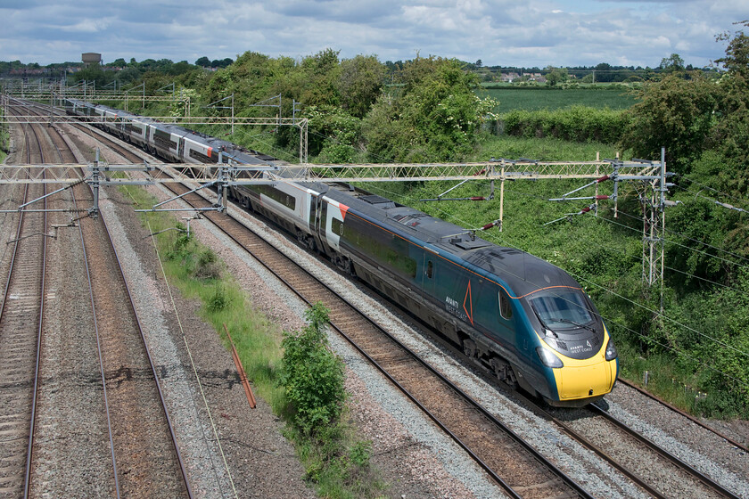 390046, VT 10.20 Manchester Piccadilly-London Euston ECS (5A11, 1L), Victoria bridge 
 390046 works the 10.20 Manchester to Euston empty stock move past Victoria bridge just south of Roade. Running as 5A11 the Pendolino has run via the Northampton loop rather than going via the Weedon mainline as is fairly common on Sunday mornings. It was one of the last diverted services as just a second or two after this photograph was taken another Pendolino came around the curve on the fast line slowing rapidly as it was going to be held at Hanslope Junction (about two miles south of this location) allowing 390046 to cross over in front of it. I would have thought that an ECS working would have been held allowing the service train to have priority but who am I to question a signaller's decision! 
 Keywords: 390046 10.20 Manchester Piccadilly-London Euston ECS 5A11 Victoria bridge Avanti West Coast Pendolino