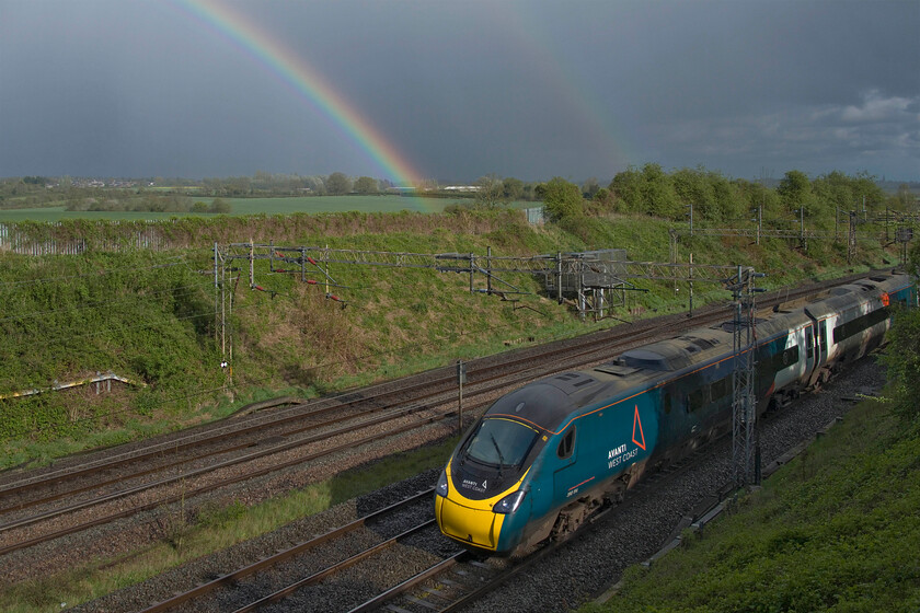 390114, VT 16.40 London Euston-Edinburgh Waverley (9S93, 1L), Victoria bridge 
 Under a dramatic sky looking south-east from Victoria bridge just south of the Northamptonshire village of Roade the 16.40 Euston to Edinburgh is seen worked by 390114 'City of Manchester'. Chances of capturing rainbows in railway images are few and far between so to manage a double rainbow is even rarer. The storm that had just passed saw a six-degree drop in temperature along with torrential rain, hail and some sleet, a classic British spring day! 
 Keywords: 390114 16.40 London Euston-Edinburgh Waverley 9S93 Victoria bridge AWC Avanti West Coast