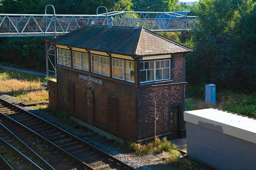 Sutton Bridge Junction signal box (GWR, 1913) 
 Sutton Bridge Junction signal box is a GWR Type 7 signal box built in 1913. It nestles down in a cutting in the suburbs of Shrewsbury, hence the heavy shadows in this image. It now only controls the junction with the Welshpool line. The next block post to the south is Dorrington five rail miles away. Note that it has had its three windows on the lower level rather crudely boarded up but it's good to see that it still retains the traditional three over two window arrangement on the upper level. 
 Keywords: Sutton Bridge Junction signal box