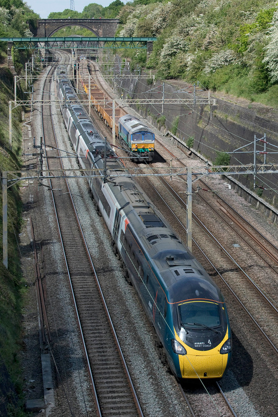 390156, VT 12.16 Manchester Piccadilly-London Euston (1A25, RT) & 66711, 12.00 Willesden-Bescot (7G52, 43L), Roade cutting 
 390156 'Pride and Prosperity' is one of the few Avanti West Coast liveried Pendolinos and is seen passing through Roade cutting forming the 12.16 Manchester Piccadilly to Euston. It is just passing the rear of the 12.00 Willesden to Bescot engineering train making its way slowly north with 66711 'Sence' on the rear. 
 Keywords: 390156 12.16 Manchester Piccadilly-London Euston 1A25 66711 12.00 Willesden-Bescot 7G52 Roade cutting JNA wagons sence Pendolino Avanti West Coast Pride and Prosperity