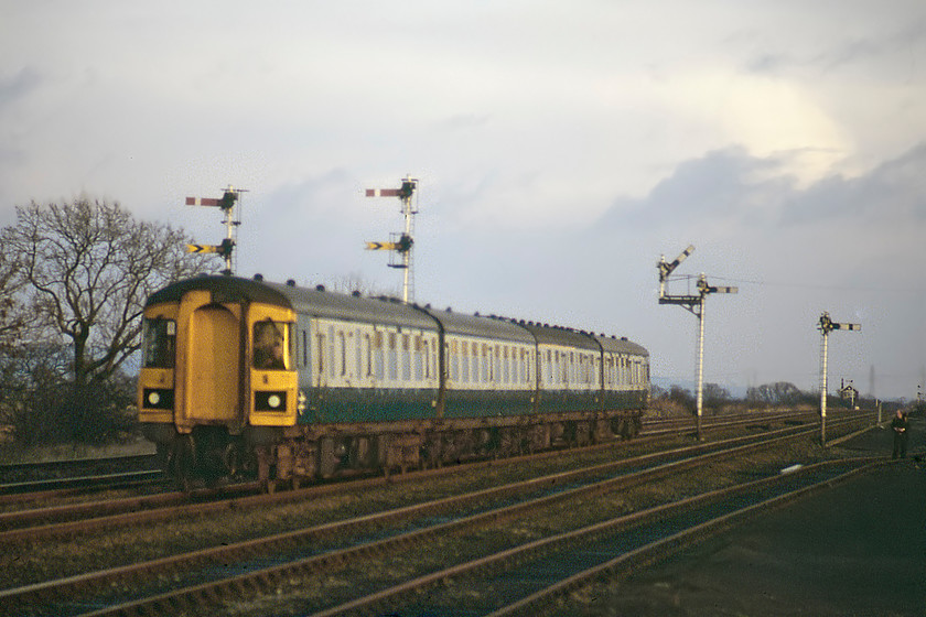 Class 123 DMU, 14.43 Hull-Sheffield, Gilberdyke station 
 A four-car Class 123 DMU takes the centre road through Gilberdyke station forming the 14.43 Hull to Sheffield service. These Swindon built Inter-City units predated the Class 124s that were also seen on this route working various trans-Pennine services. They were very similar to the later units but had connecting doors for multiple working. Like the Class 124s, none have survived into preservation largely due to extensive use of asbestos in their construction. However, a number of plans have been made to rebuild a set from existing preserved Mk1 coaches; none of which have yet come to fruition. 
 Keywords: Class 123 DMU 14.43 Hull-Sheffield Gilberdyke station